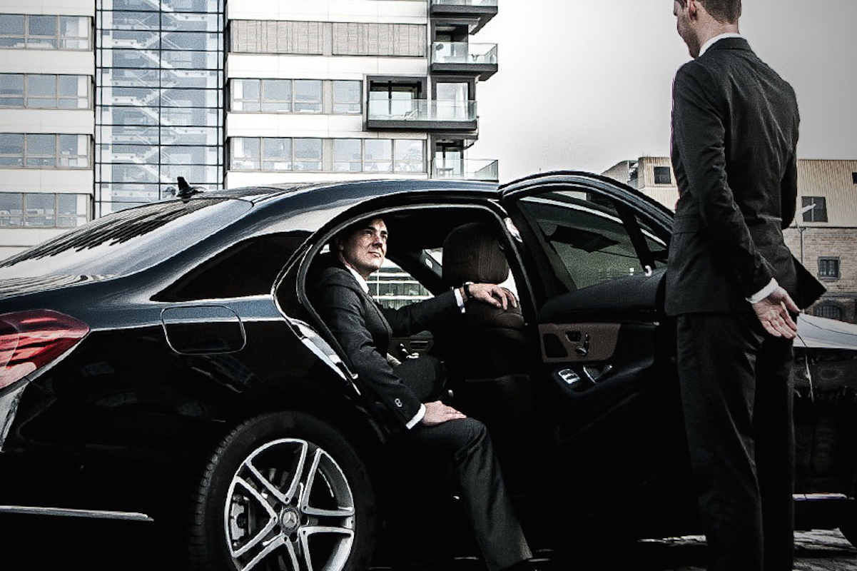 bl slider chauffeur opening limousine door for businessman2